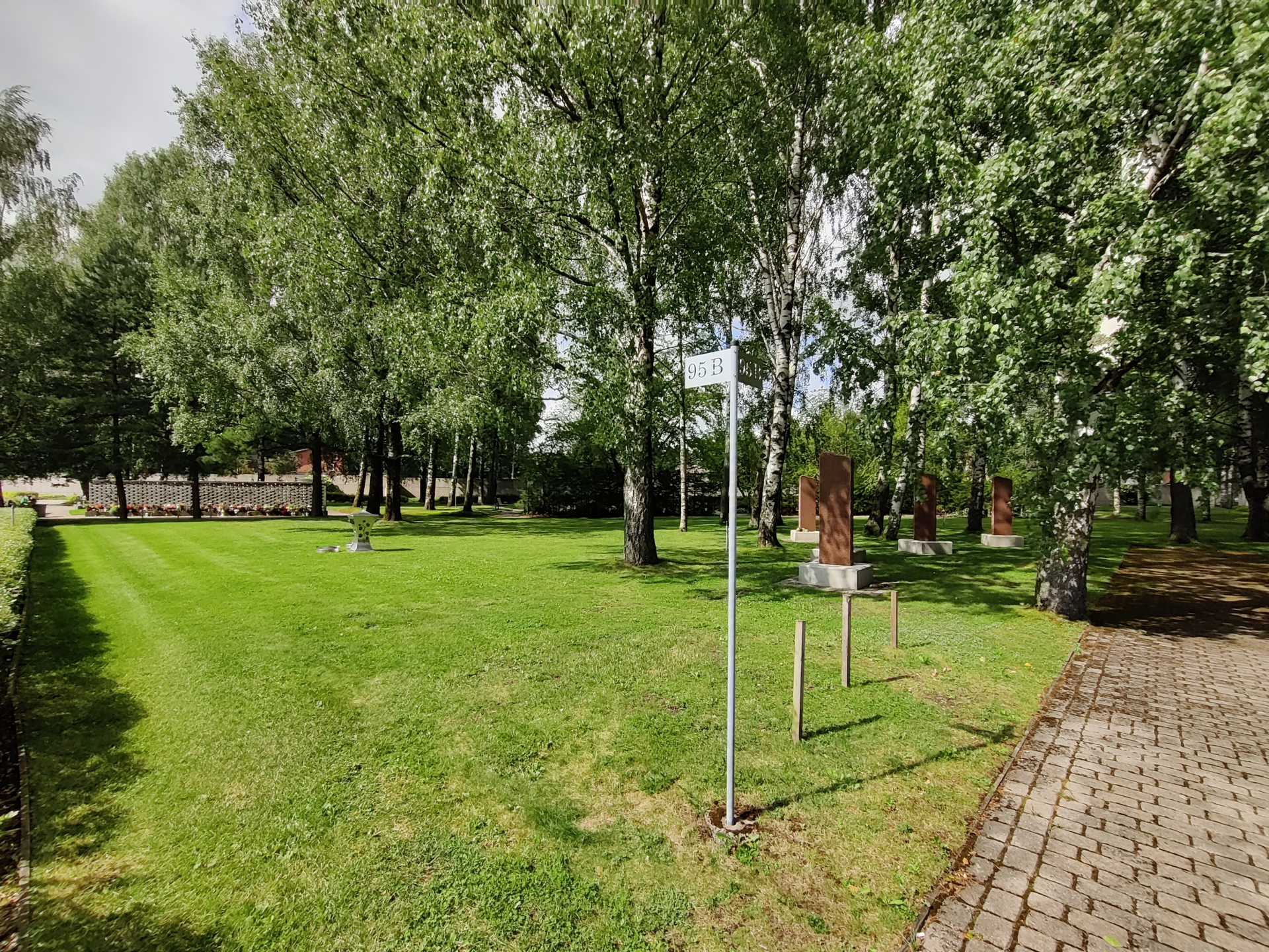 Malmi 95B muistolehto. Nurmialue, jossa graniittiset kivipaasit muistolaattoja varten.